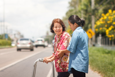 caregiver assisting woman in walking