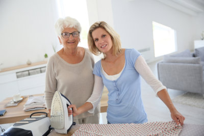 caregiver ironing her patient's clothes